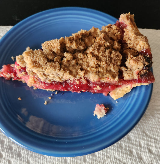 Cranberry apple crumb pie recipe slice on a blue plate with buttery crumb topping and vibrant filling.